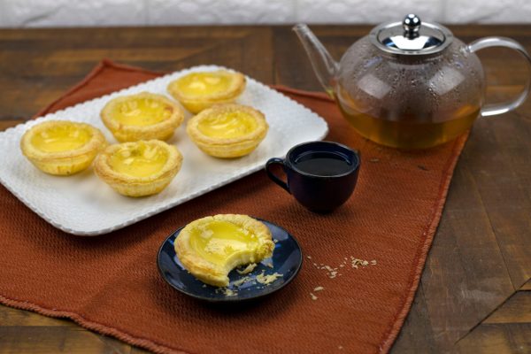 Some cut lil' egg tarts sitting on a plate